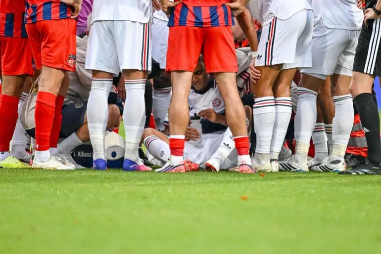 Bayern Munich’s Jamal Musiala, bottom, receives treatment after collapsing